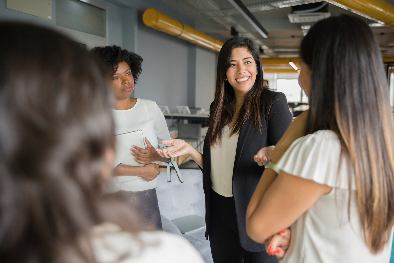 Smiling Asian woman networking with other women