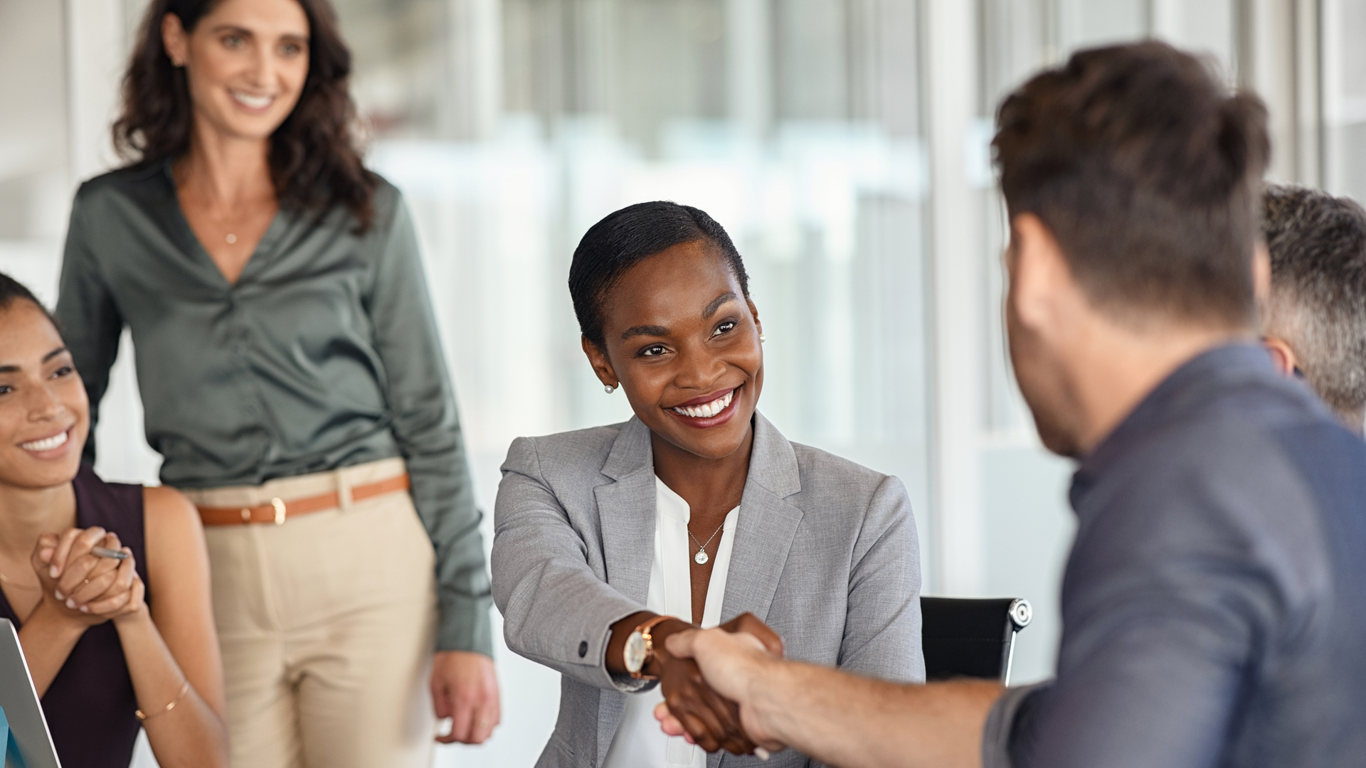 Professional African American woman shaking hands at meeting